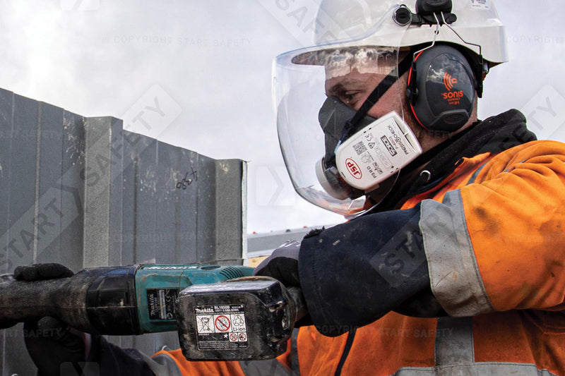 Construction Worker Drilling While Wearing Ear Defenders