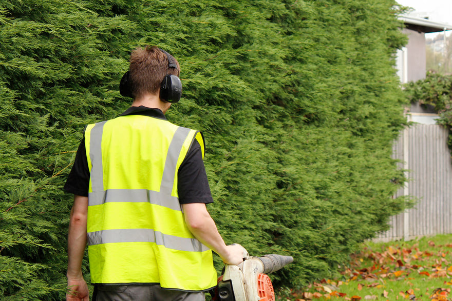 Gardener & Landscaper Wearing A Hi-vis Waistcoat While Blowing Leaves