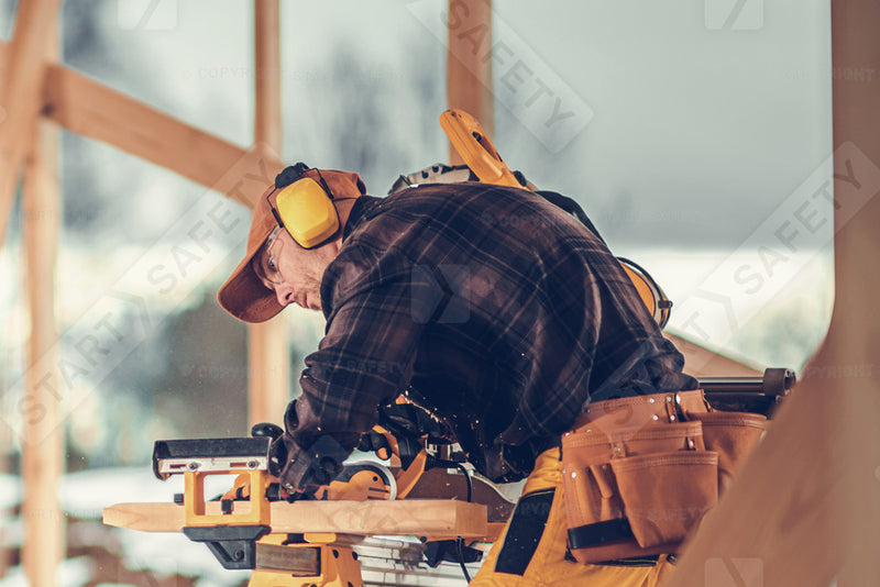 Construction Worker Cutting While Wearing Ear Defenders