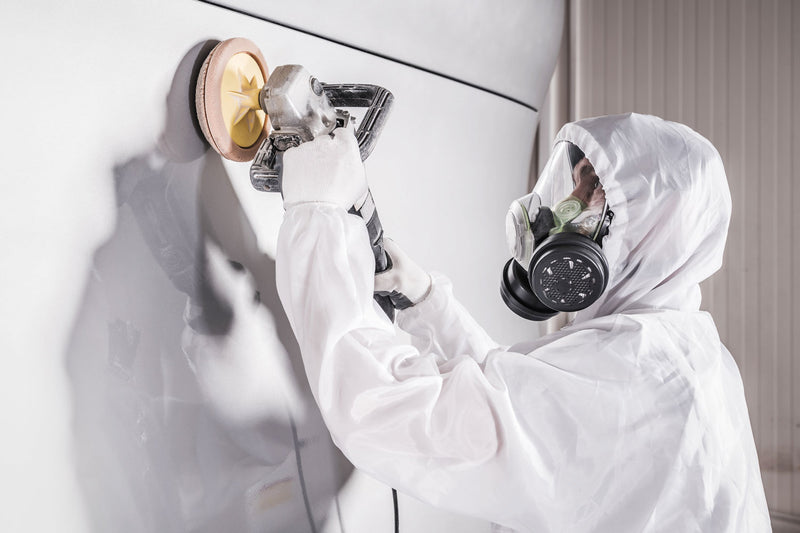 Worker Wearing A Full Face Mask While Polishing Newly-Painted Bus