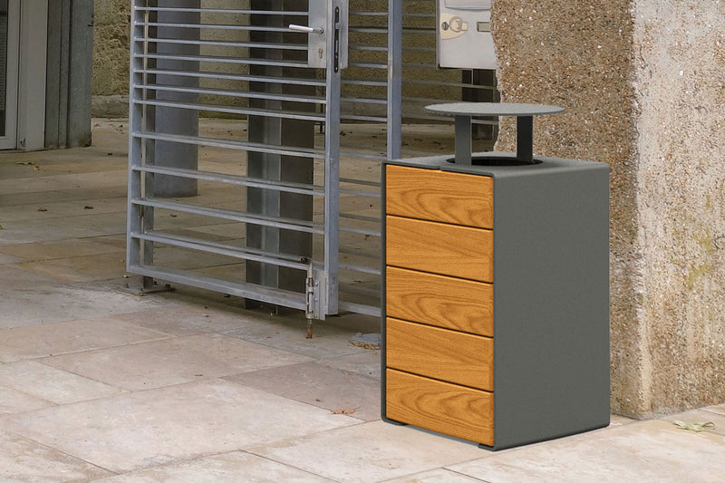 Procity Kube Bin With Lid In Wood installed next To Town Wall