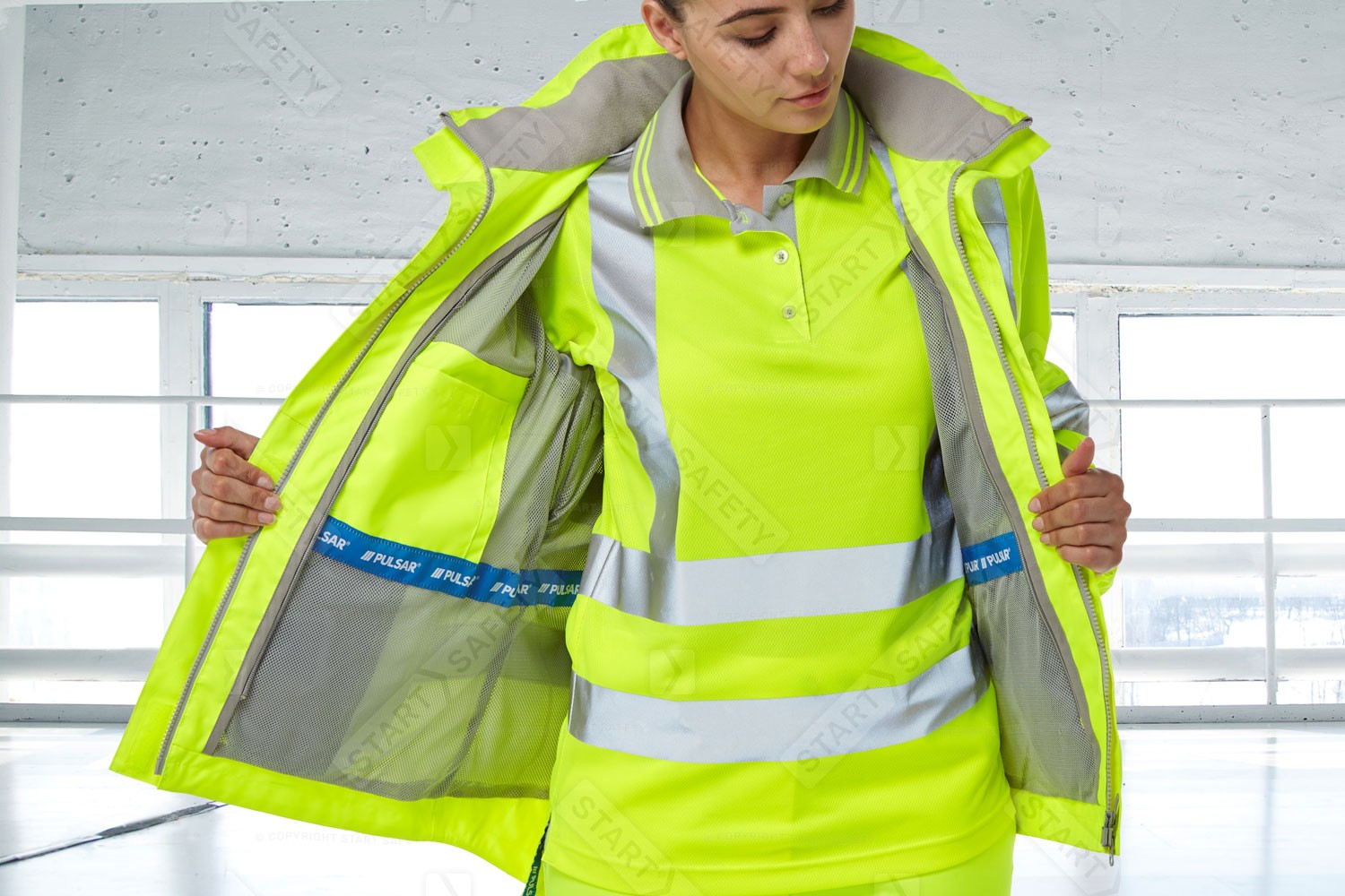 Woman Wearing A Pulsar P700 Short Sleeved Polo Shirt Underneath A Storm Coat