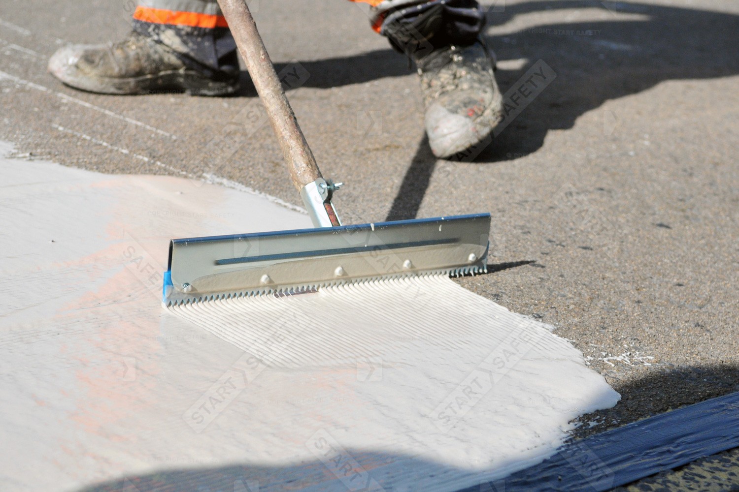 Serrated Squeegee Being Used To spread MMA Floor Coating