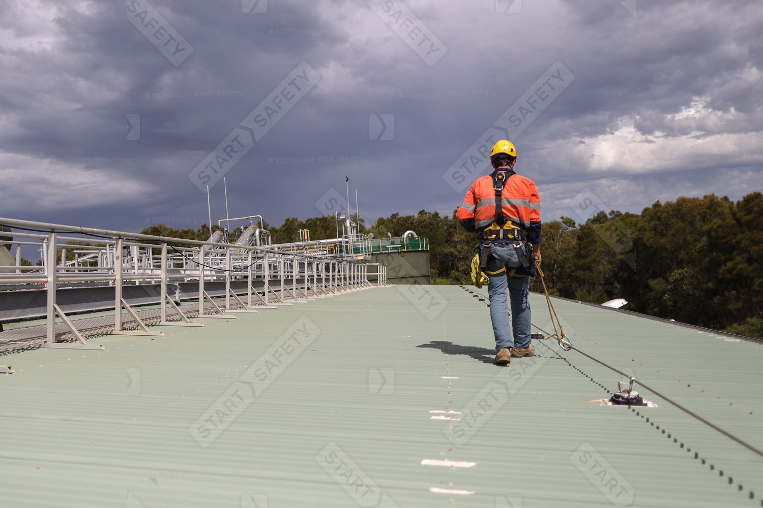 Worker On Roof Attached To A Lifeline With A Fall Restraint Lanyard