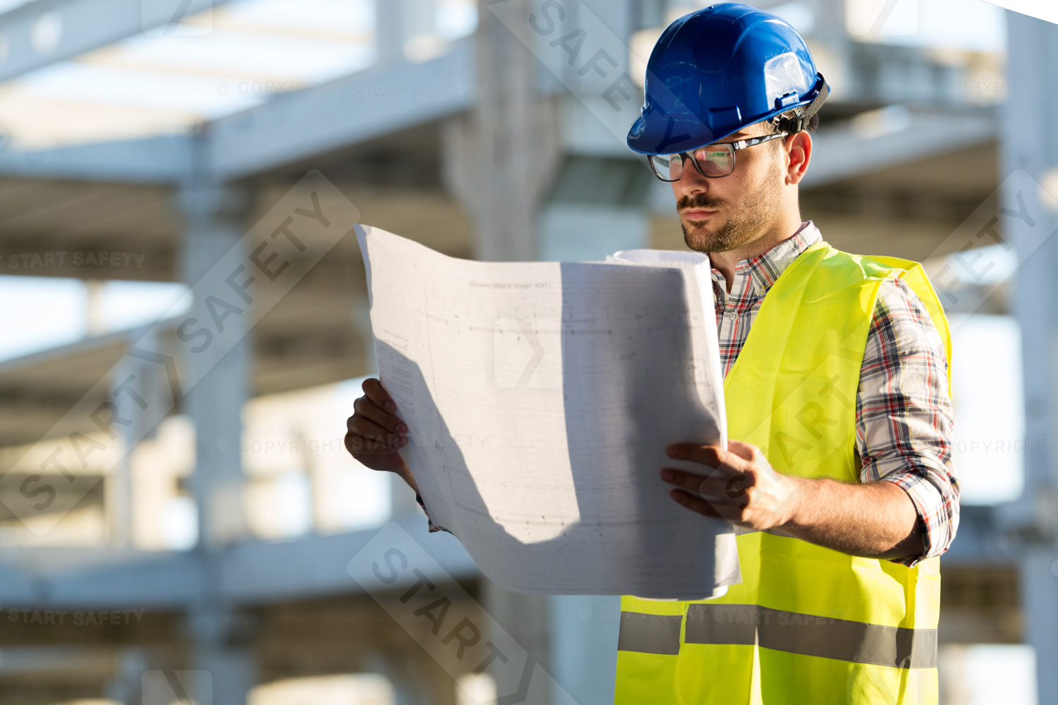 Construction Site Visitor Wearing A Blue Hard Hat While Consulting Plans