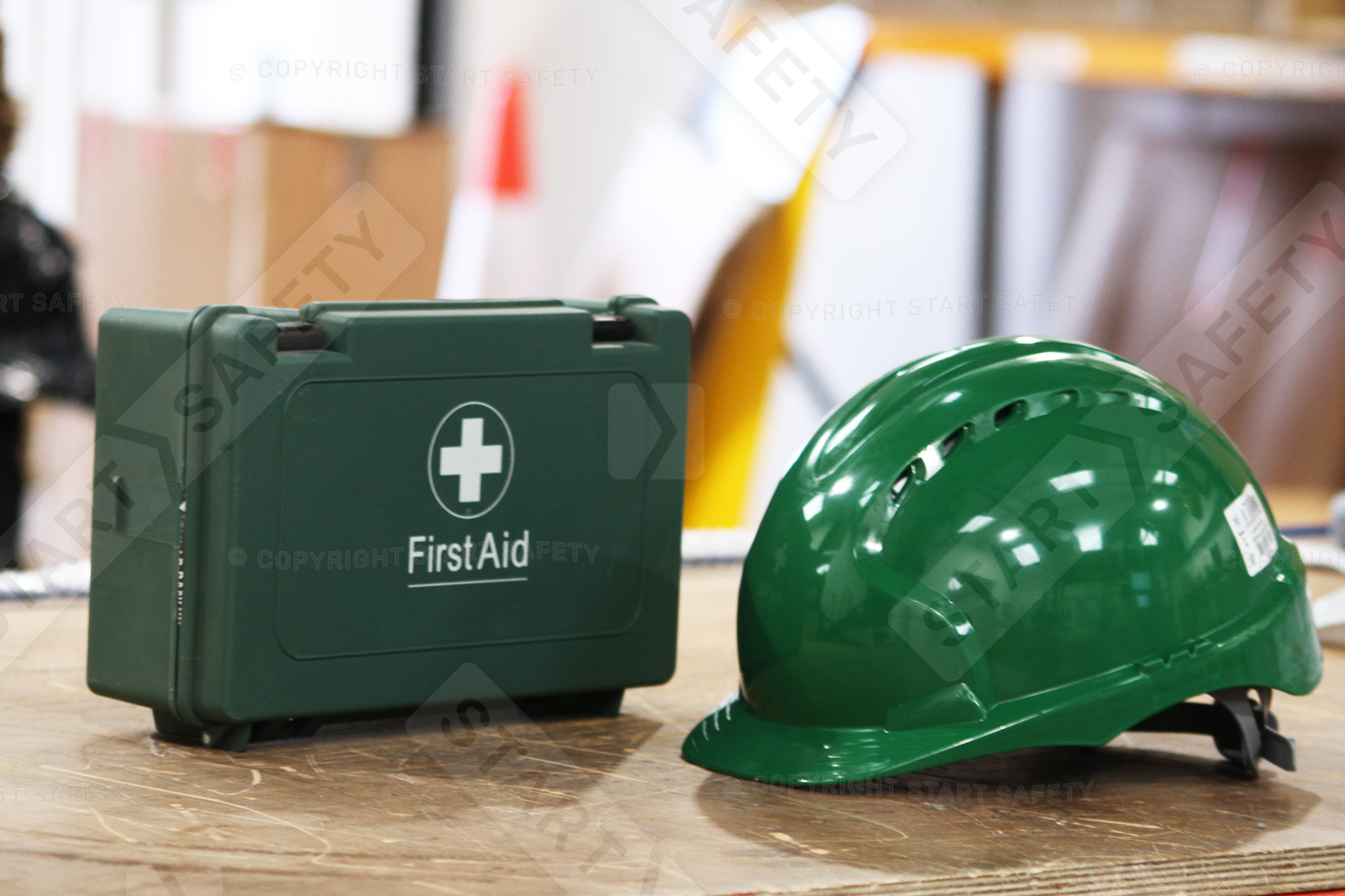 Green Hard Hat Next To A First Aid Case