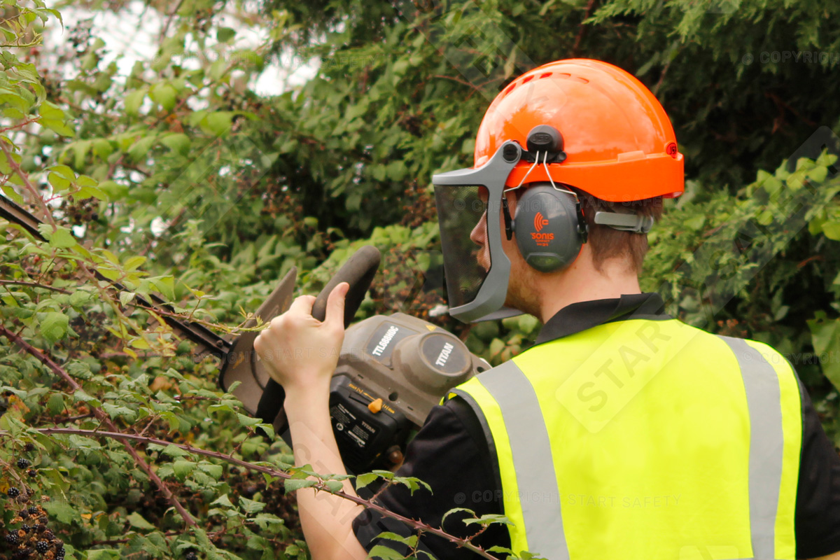 Hedge Cutter Wearing A Hard Hat With Ear Defenders