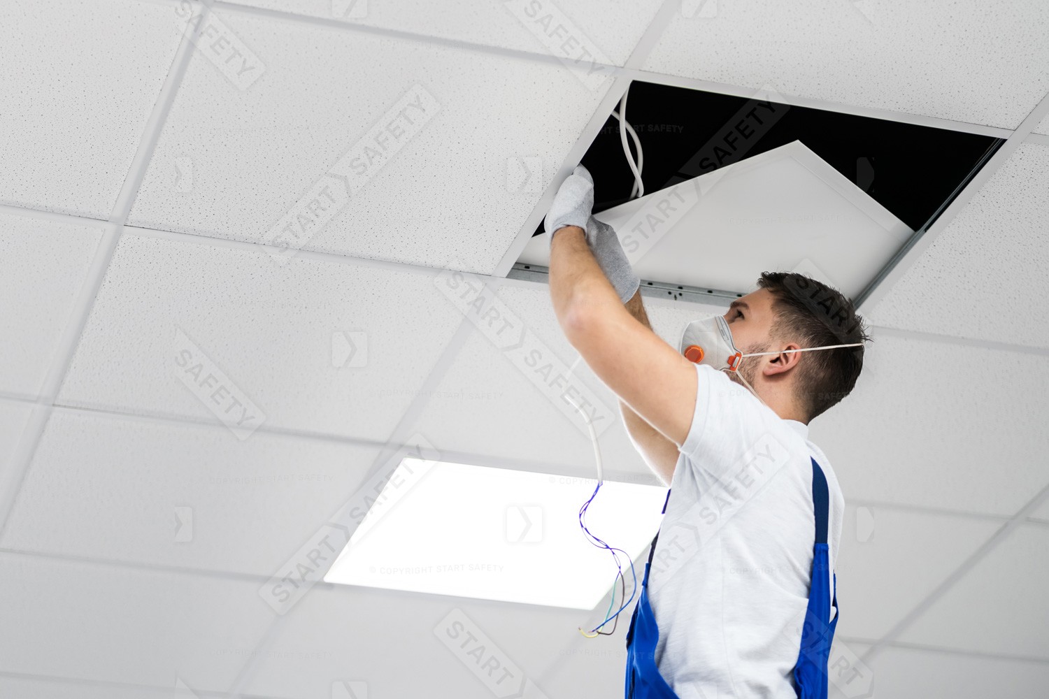 Maintenance Operative Working Around Dusty Ceiling Tiles