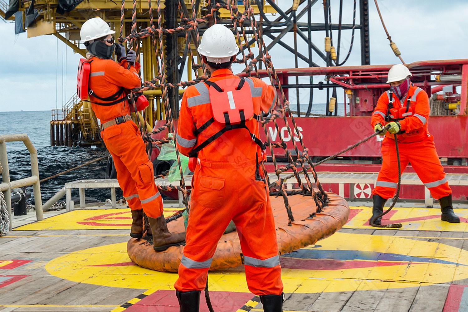 Workers On An Oil Rig Wearing Hi Vis Overalls