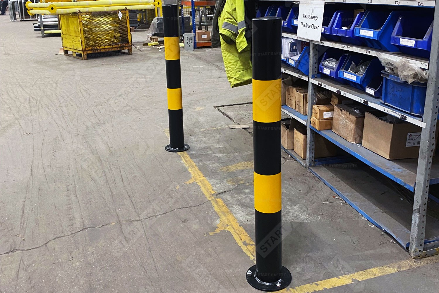 Bolt down yellow and black bollard installed on factory floor