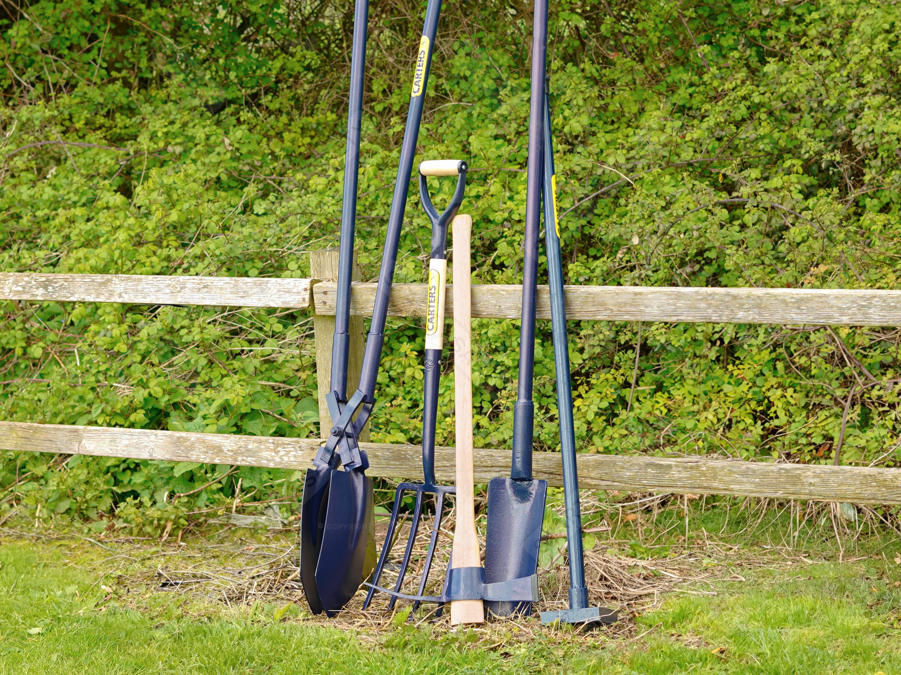 carters manmade tools leaning against a fence