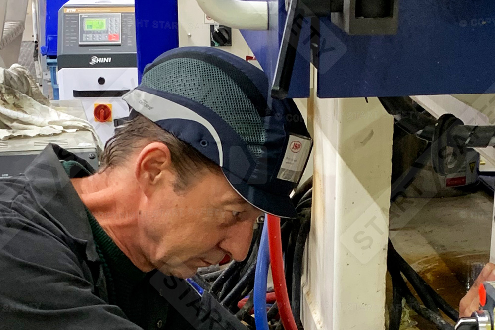 Worker Doing Maintenance While Wearing A Bump Caps
