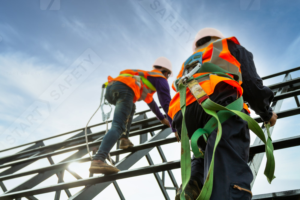 Two Workers With Hard Hats Climbing A Steel Frame